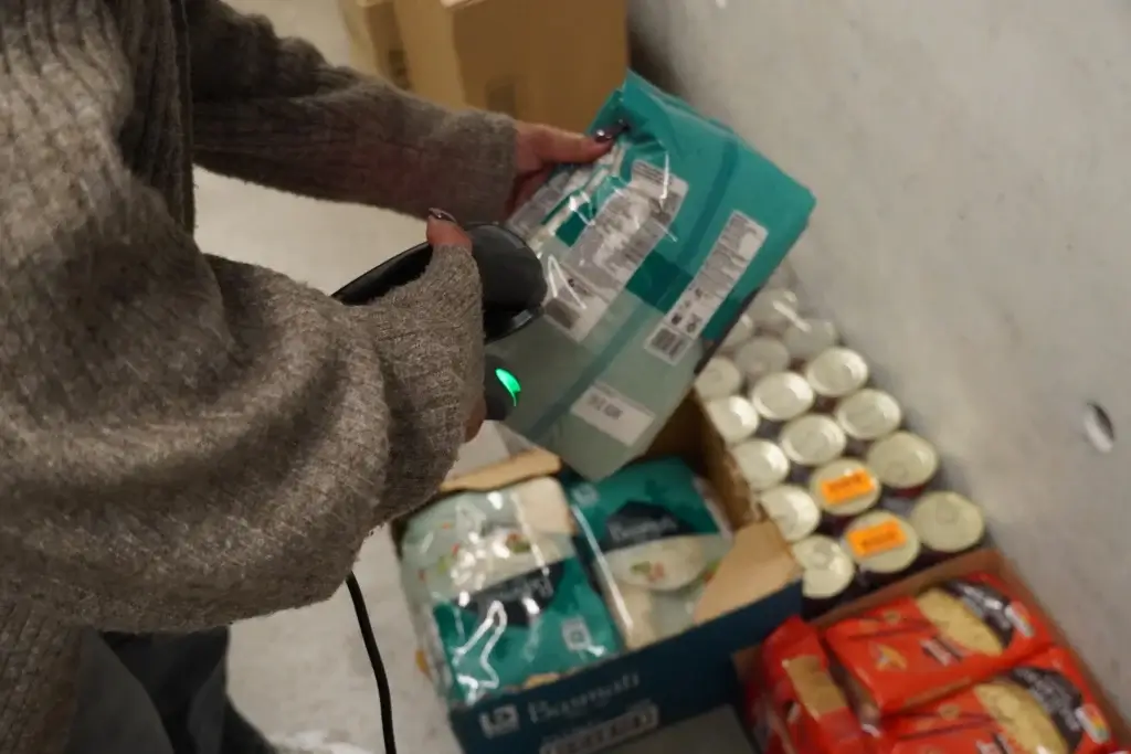 Bénéficiaire de l'épicerie sociale EPI scannant ses produits alimentaires