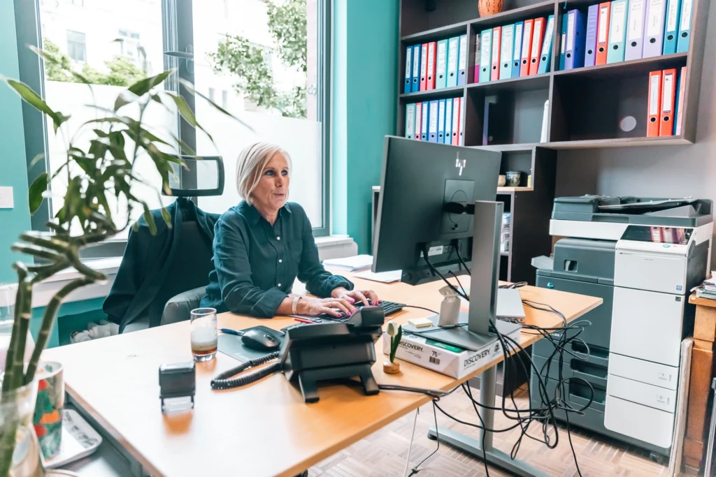 Assistante sociale en entretien téléphonique à son bureau